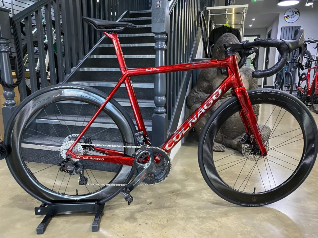 A red colgano road bike standing on a trainer.