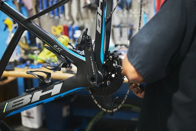 A person repairing the groupset of a bike.