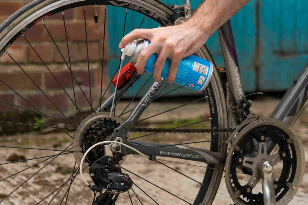 A person Greasing his bicycle chain.
