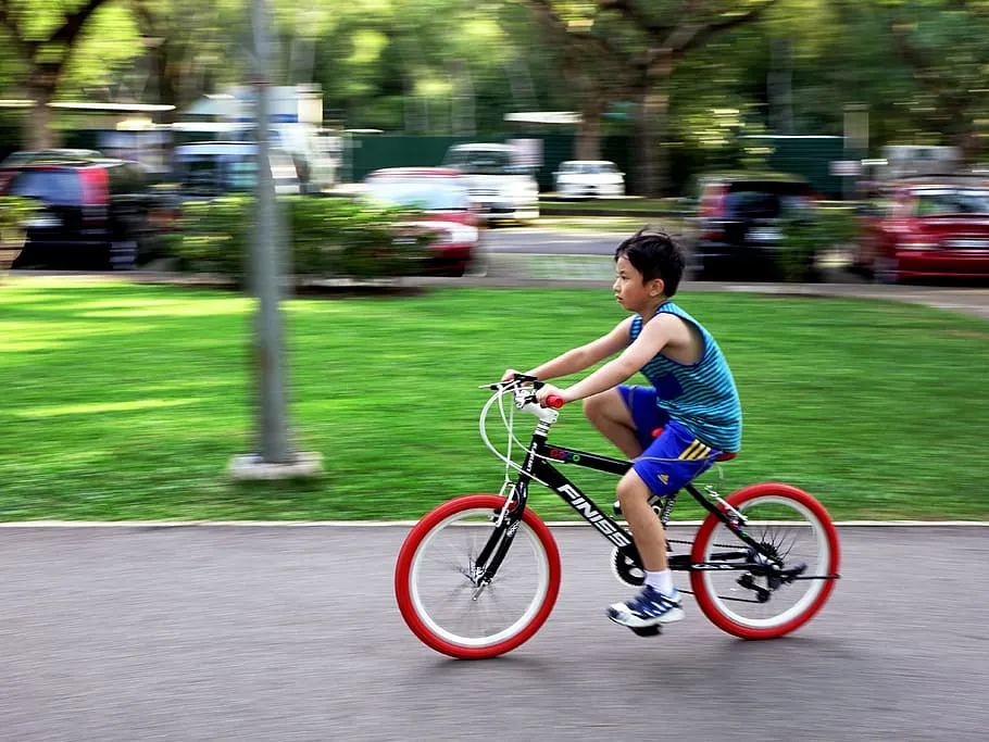 A kid riding his bicycle outside.