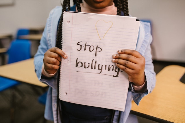a girl holding a very important message to stop bullying