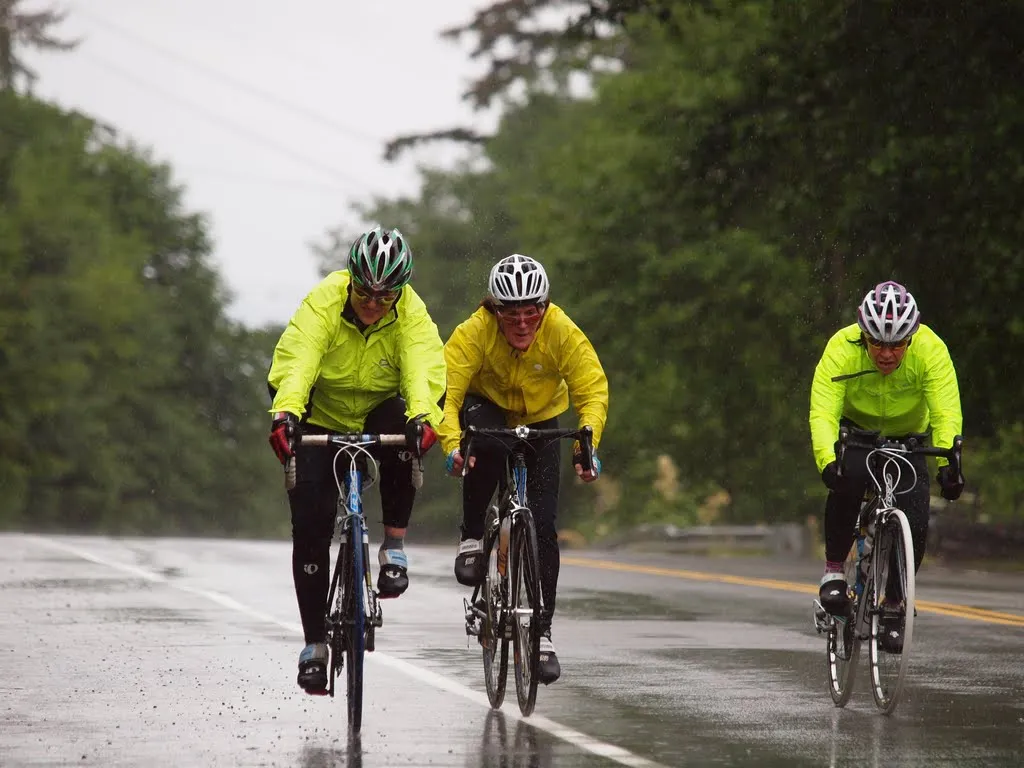 Three Cyclist Riding in the Rain.