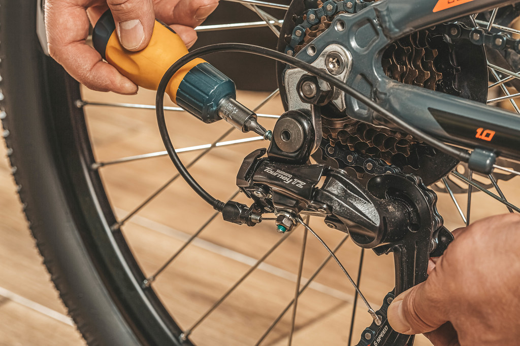 a person repairing a derailleur of a bicycle